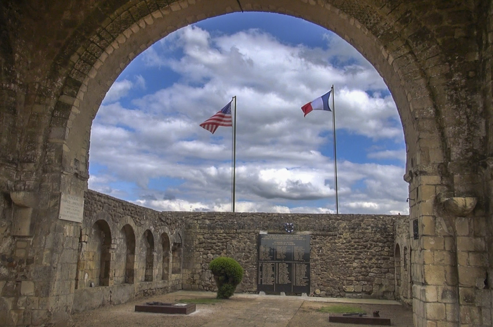american and french flags above a world war 2 memorial