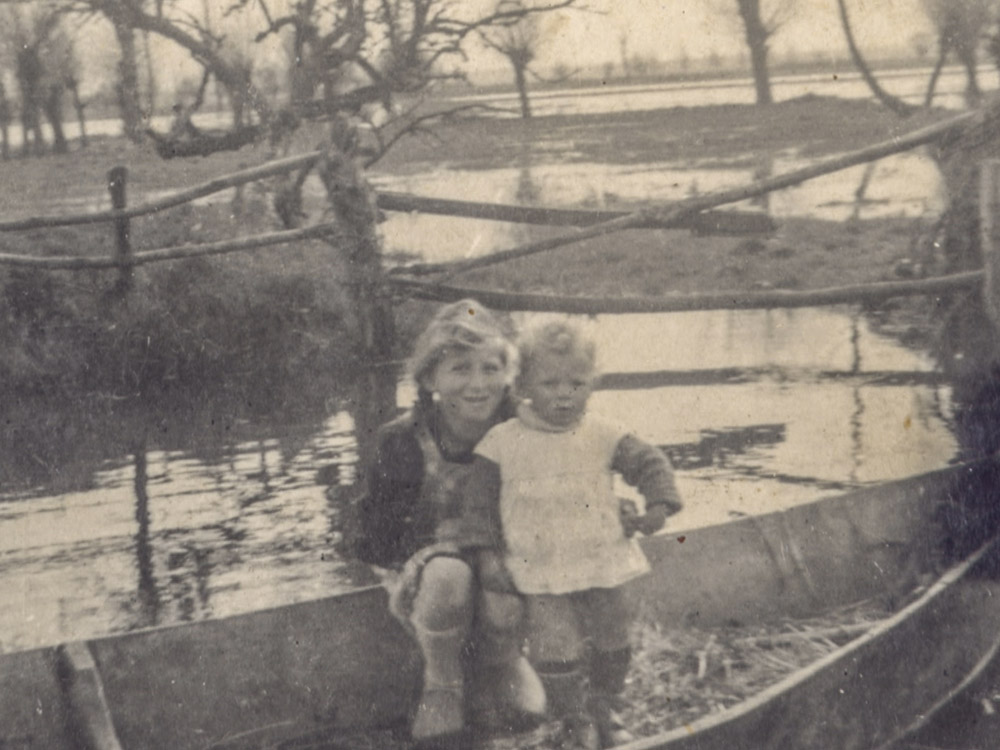 black and white photo of two children in small rowboat