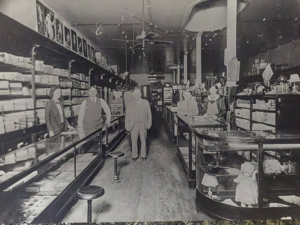 old black and white photo of people posing for picture inside old store