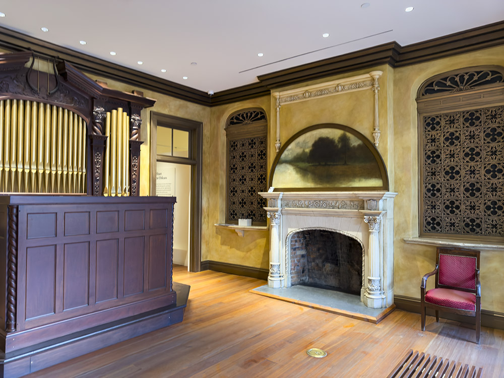 aeolian organ and pipes and fireplace in room with golden walls