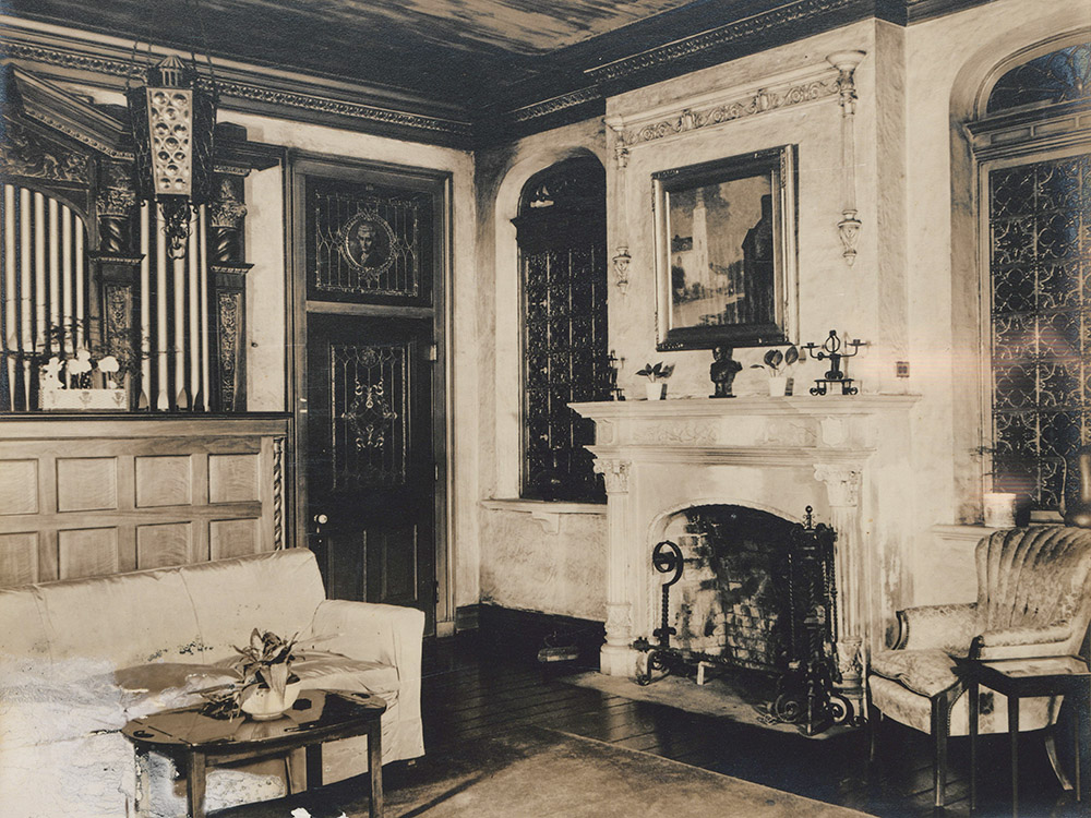 old black and white phto of fireplace and pipe organ in parlor