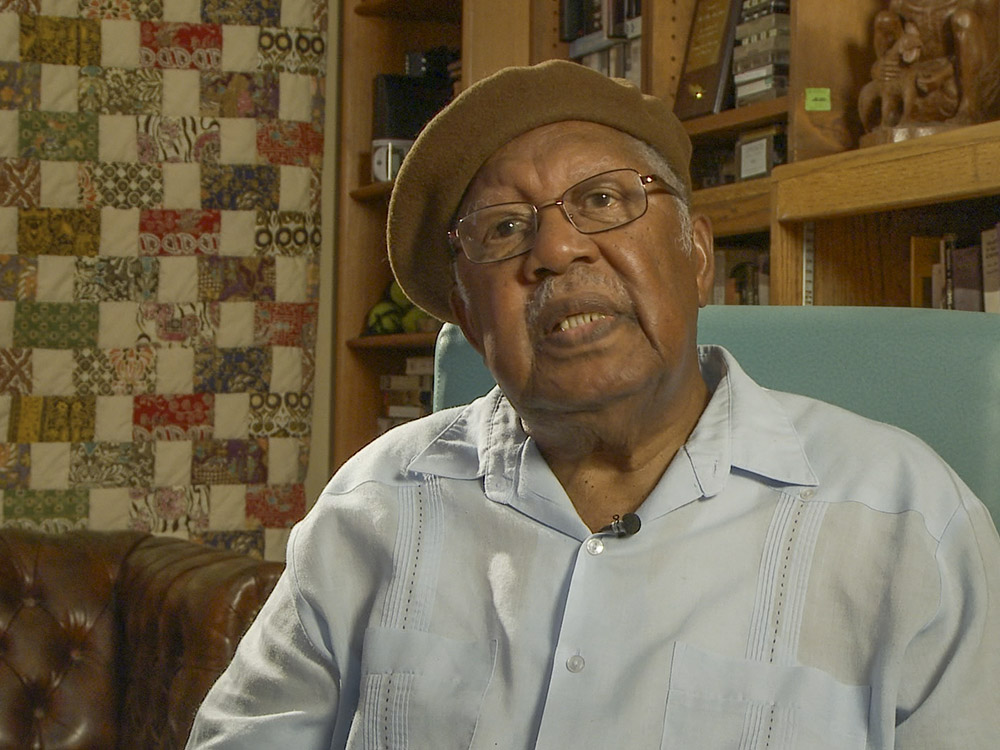 photograph of author ernest gaines sitting in chair talking